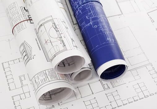 Rolled-up blueprints and house plans with copyspace